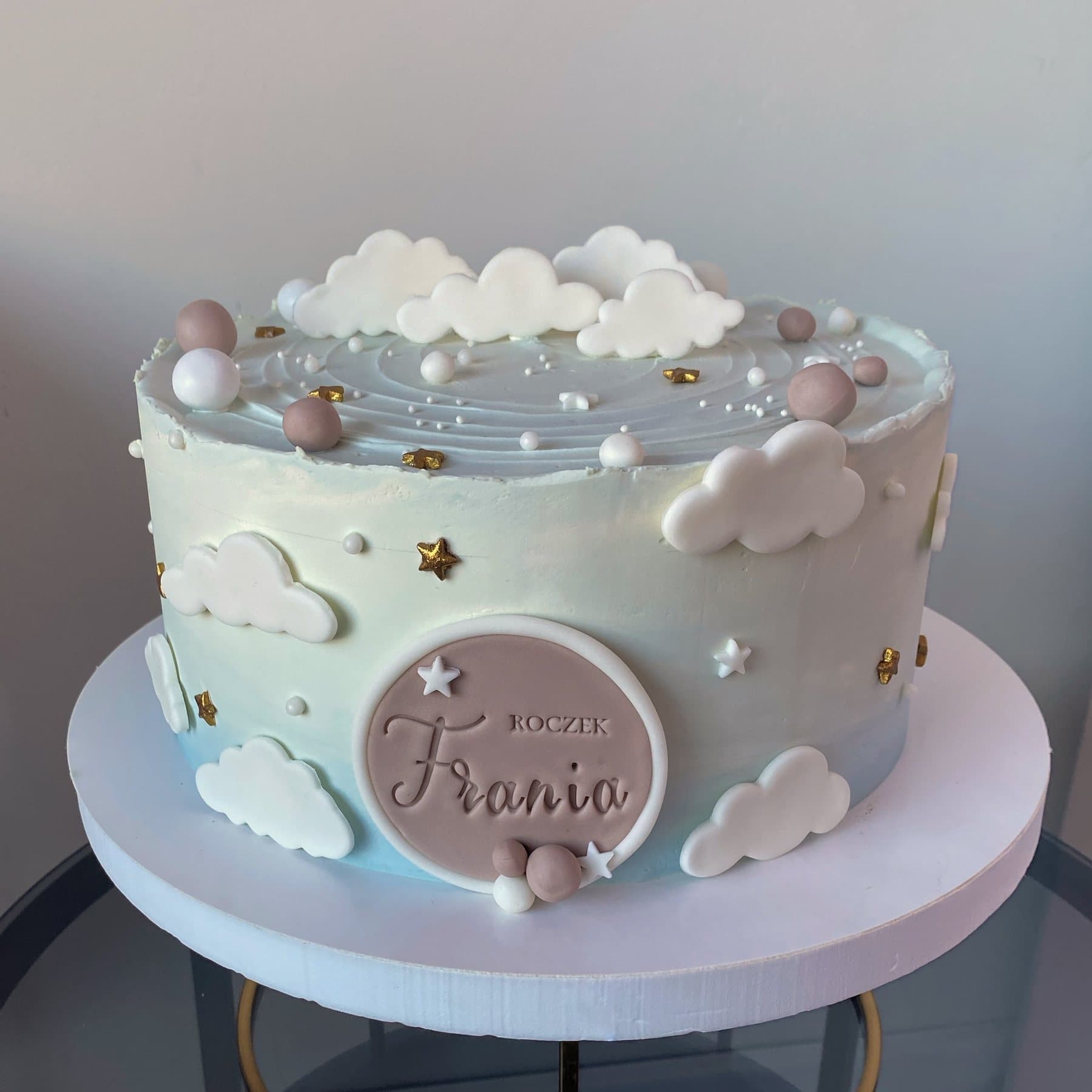 Pastelowy tort w motywie chmurek na roczek